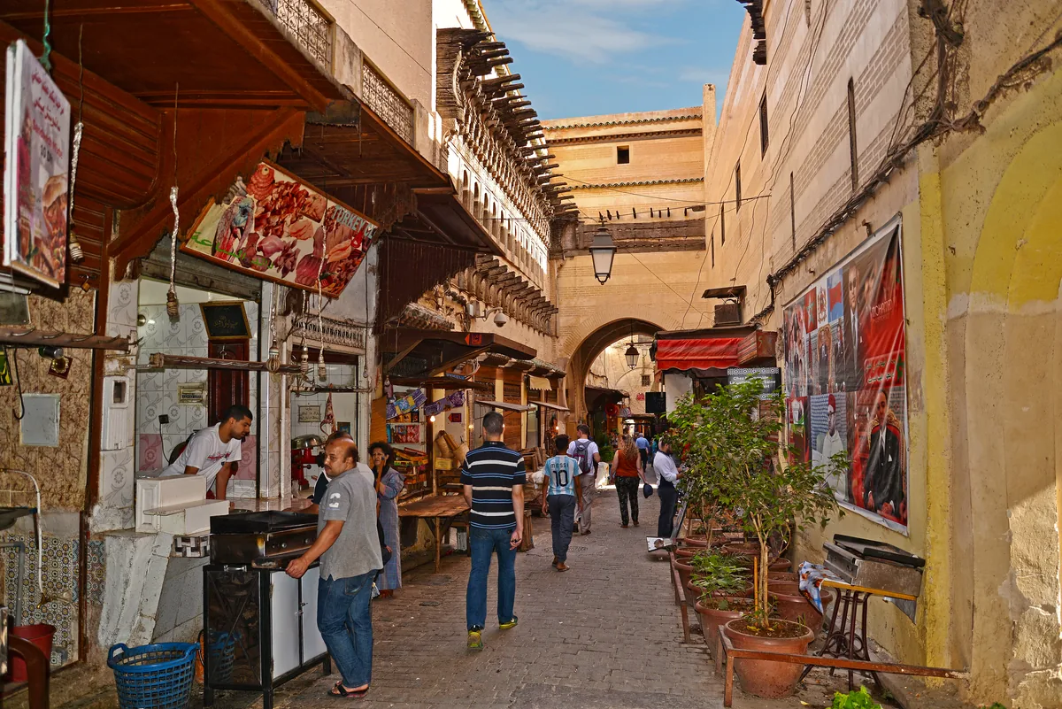 Vibrant narrow alleyways in Fes el-Bali with pedestrian traffic and artisan stalls